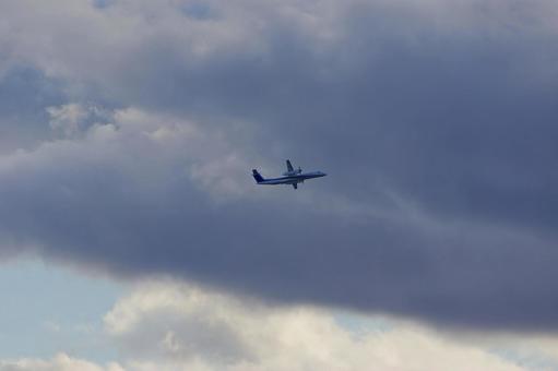 雲を背景に飛ぶプロペラ旅客機 飛行機,プロペラ機,航空機の写真素材