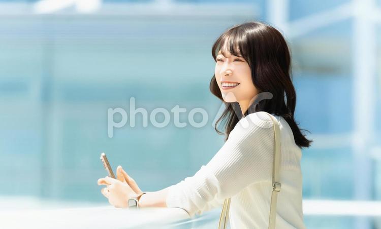 屋外でスマホを持つ女性・ビジネスウーマン 女性,スマホ,スマートフォンの写真素材
