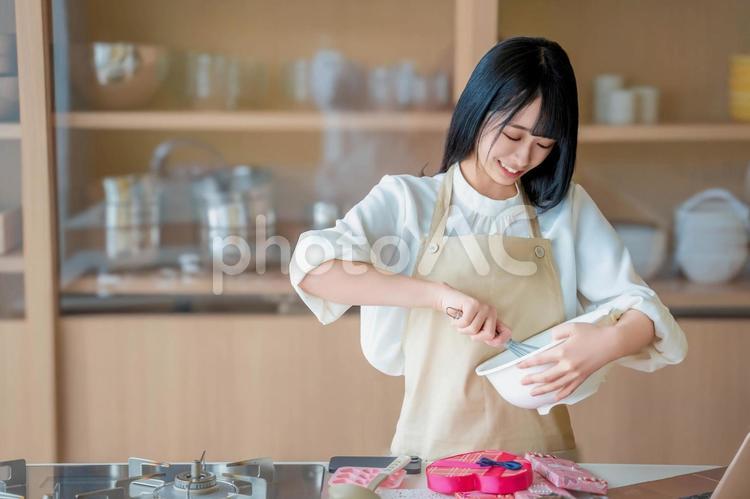 楽しそうにチョコを料理をする女性料理人 バレンタイン,バレンタインデー,チョコの写真素材