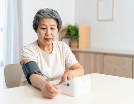 血圧を測り不安そうな表情するシニア女性 血圧を測り不安そうな表情するシニア女性の写真