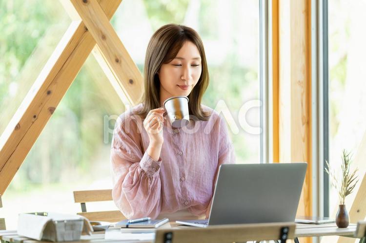 カフェでパソコンを使って仕事をする女性 女性,パソコン,ノートパソコンの写真素材