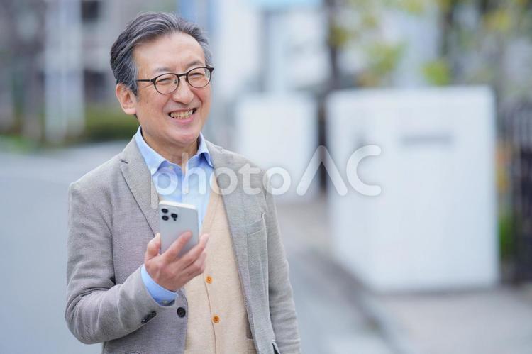 屋外でスマートフォンを持っている高齢男性 男性,おじいちゃん,1人の写真素材