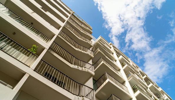 マンションを見上げる 青空背景 マンションを見上げる 青空背景の写真