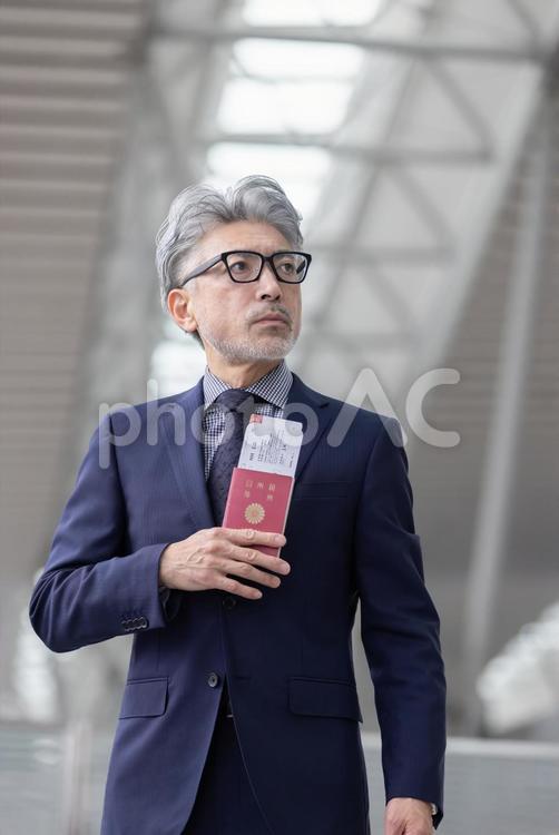 ミドル男性　空港　出張　ダミーチケット ビジネス,空港,ミドルの写真素材