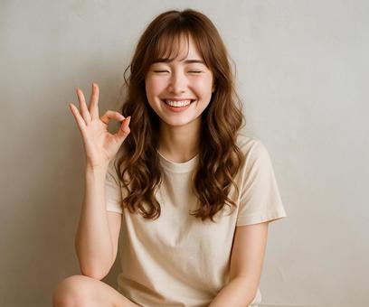 ポジティブな表情でOKを出す若い女性 ポジティブな表情でOKを出す若い女性の写真