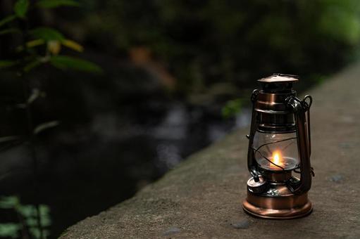 川の近くに置かれたアンティークランタン 川の近くに置かれたアンティークランタン ランタン,カンテラ,グランピングの写真素材