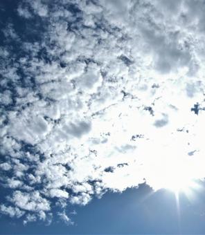 細かい模様の白い雲の間からさす 陽の光 細かい模様の白い雲の間からさす 陽の光の写真