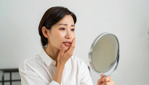 ビューティーイメージ 鏡を見て悩む女性 ビューティーイメージ 鏡を見て悩む女性の写真