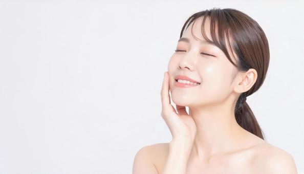 ビューティー　肌を満足げに触る女性の写真