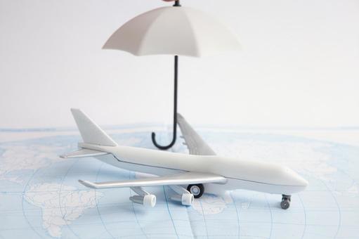 傘と飛行機のモチーフ 旅行保険,傘,飛行機模型の写真素材