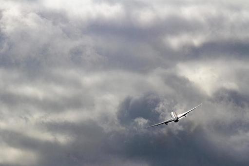 曇天を駆け上がる飛行機の後ろ姿 曇天を駆け上がる飛行機の後ろ姿の写真