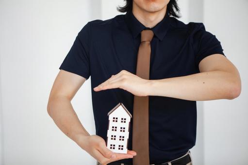 模型の家を守ろうとする男性スタッフの手元 保険業,事務職,接客業の写真素材