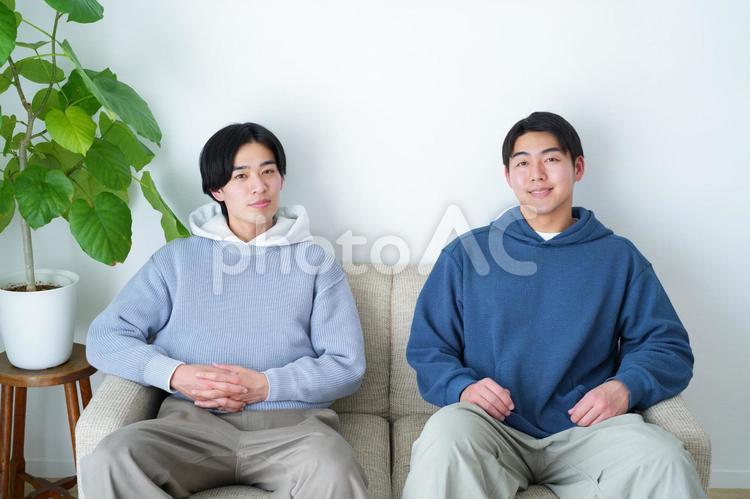 ソファに座っている正面を向いた2人の男性 引っ越し,一人暮らし,男性の写真素材