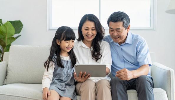 PCを操作する日本人のシニア夫婦と孫 PCを操作する日本人のシニア夫婦と孫の写真