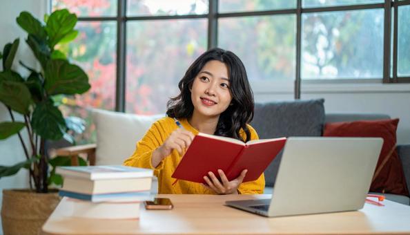 秋、部屋の中で勉強する日本人女性 秋、部屋の中で勉強する日本人女性の写真