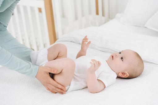 赤ちゃんの太ももを触る手元 赤ちゃんの太ももを触る手元 赤ちゃん,かわいい,仰向けの写真素材