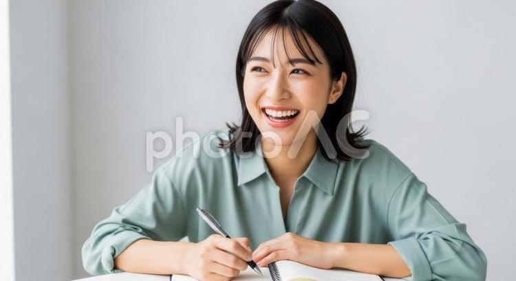 ノートを書きながら笑顔を見せる女性 女性,学生,若者の写真素材