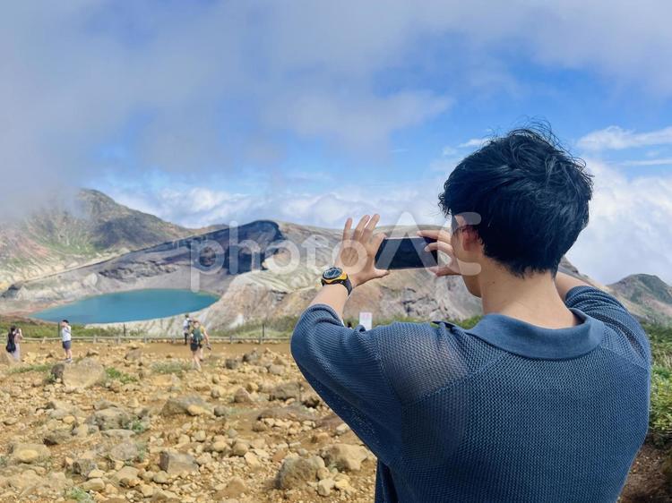 御釜を撮影する男性 御釜,宮城,山形の写真素材