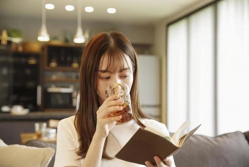 ソファに座って読書をする女性 読書,リラックス,集中の写真素材