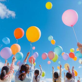 青空に舞うカラフルな風船と運動会の写真