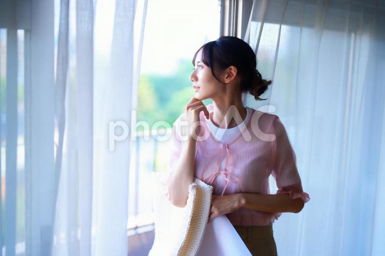 窓辺で外を見る女性の横顔 女性,人物,若者の写真素材