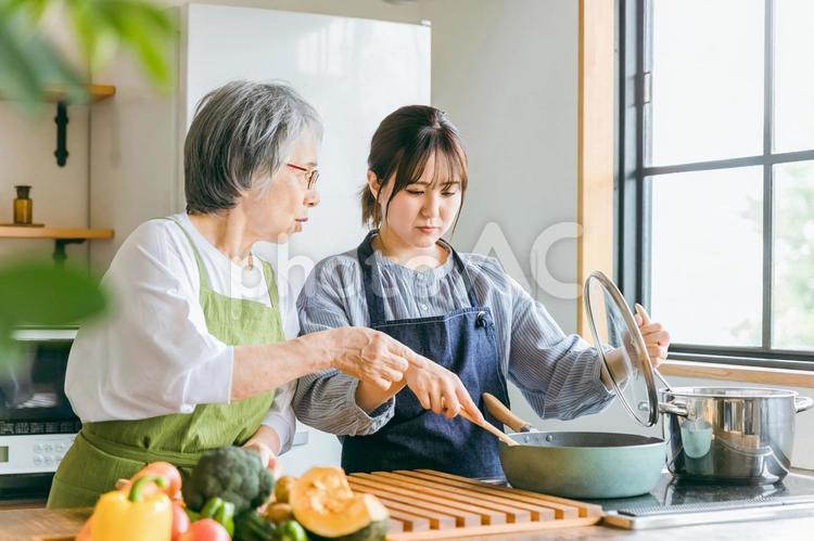 料理を見て文句を言う高齢者女性と泣く女性 嫁姑問題,義母,姑の写真素材