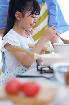 親子で料理をするキッチンの風景 女の子,鍋,混ぜるの写真素材