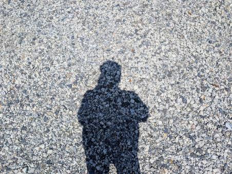 砂利の地面に落ちる人影 砂利の地面に落ちる人影の写真