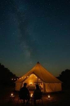 星空の下でキャンプをする夫婦 星空の下でキャンプをする夫婦の写真