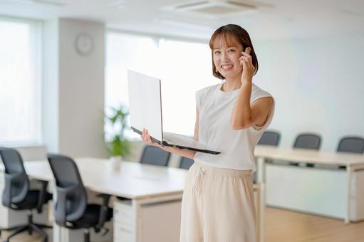 PCとスマホとオフィスと女性 女性,ビジネスウーマン,笑顔の写真素材