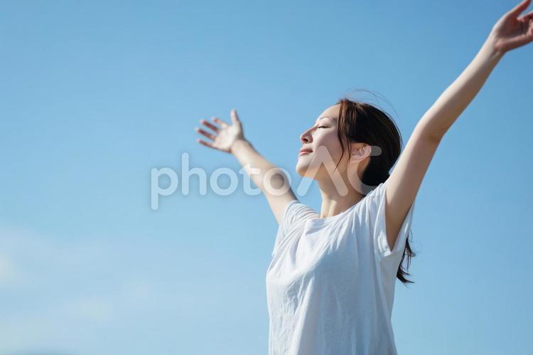 青空と自由を感じる女性 女性,若い,白tシャツの写真素材