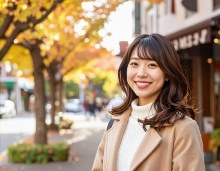 秋の街を歩く笑顔の女性 秋の街を歩く笑顔の女性の写真