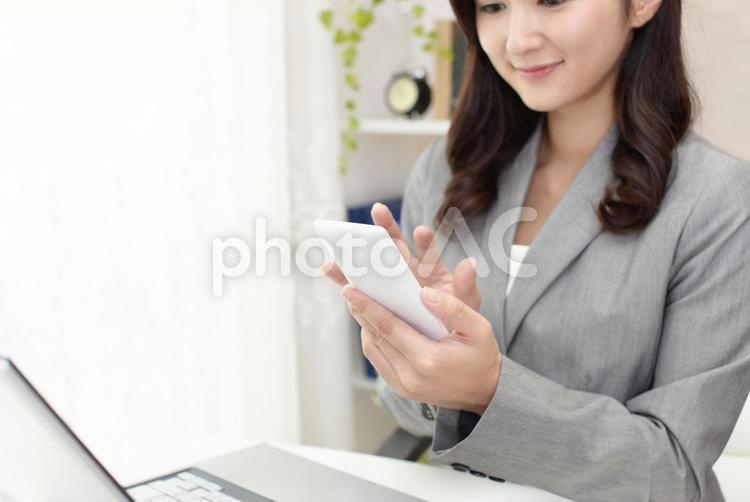 スマートフォンを持つ笑顔のビジネスウーマン 女性,ビジネスウーマン,女の写真素材