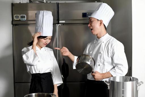 厨房で男性シェフから叱られる女性シェフ シェフ,料理人,飲食店の写真素材