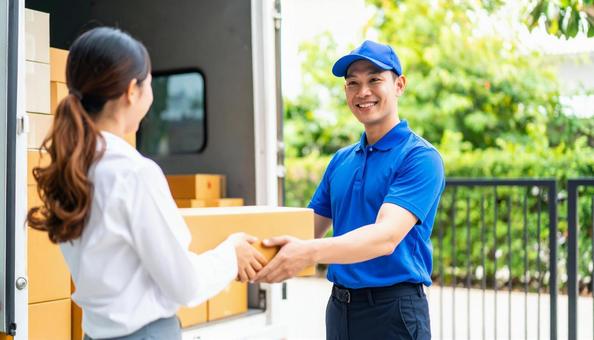 ダンボールを持つ運送業者の男女の写真