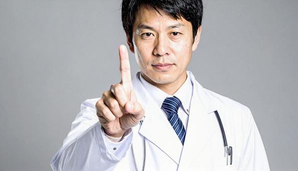 注意! 人差し指を立てる白衣を着た男性 注意! 人差し指を立てる白衣を着た男性の写真