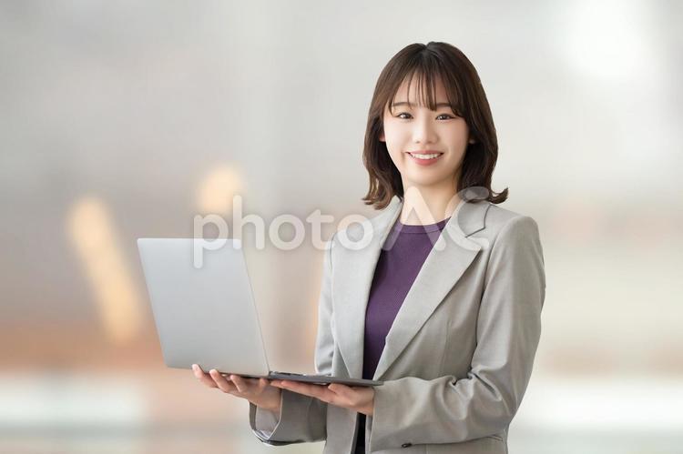 ノートパソコンを持つビジネスウーマン 女性,ビジネス,笑顔の写真素材