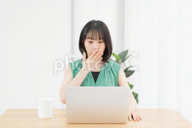 PCを使いながら驚いている若い女性 パソコン,驚く,ビックリの写真素材
