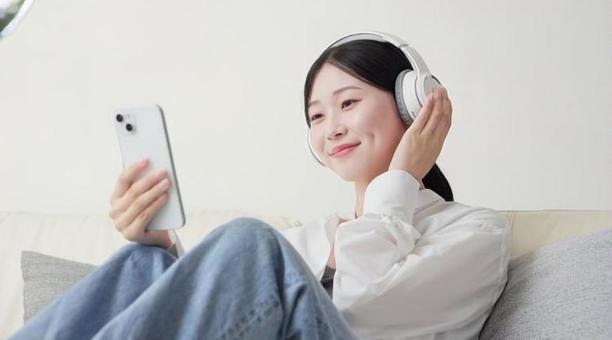 ワイヤレスヘッドフォンで音楽を聞く女性 ワイヤレスヘッドフォンで音楽を聞く女性 女性,ワイヤレス,聴くの写真素材