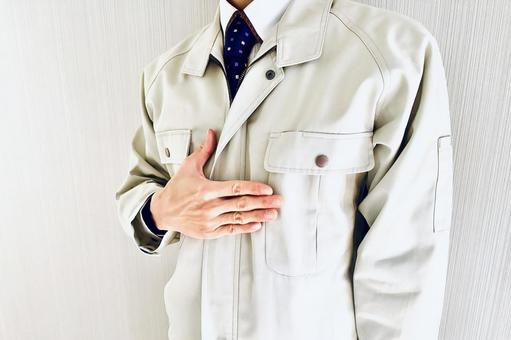 胸に手を当てる作業着姿の男性スタッフ 信頼,信用,任せるの写真素材