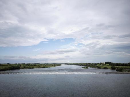 広がる河川と夏の雲空の写真