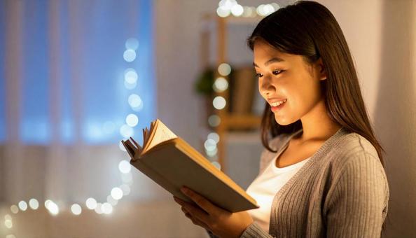 室内で読書をしている東洋人女性の写真