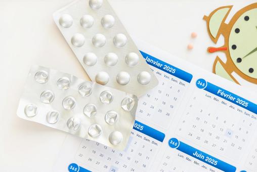 錠剤のシートとカレンダーと紙でできた時計 生理,月経,薬の写真素材