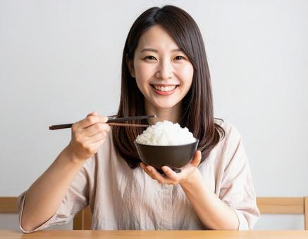 山盛りのごはん茶碗を持つ女性 山盛りのごはん茶碗を持つ女性の写真
