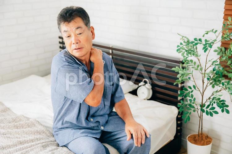 寝室で体調を崩す高齢者男性（肩こり） 高齢者,肩こり,脱臼の写真素材