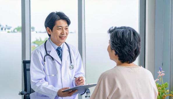 患者女性に説明する日本人医師 患者女性に説明する日本人医師の写真
