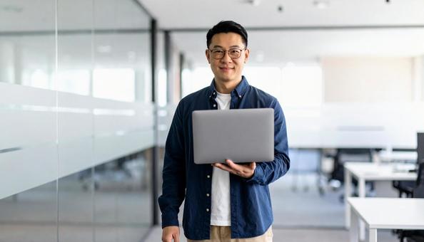 ノートパソコンを持つビジネスマンの写真