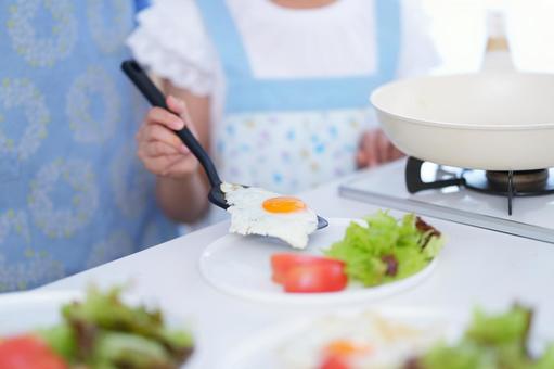 キッチンで目玉焼きを盛る子どもの手元 女の子,目玉焼き,フライ返しの写真素材