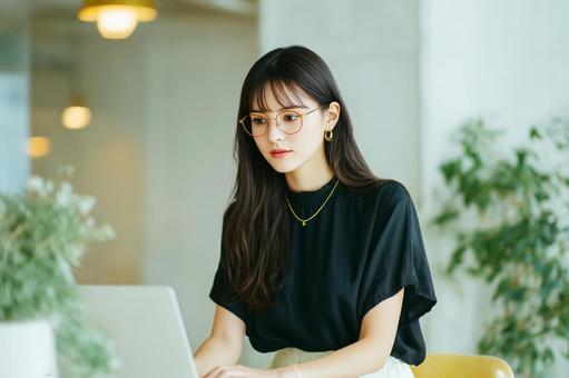 カフェでノートPCを使用して仕事中の女性 カフェでノートPCを使用して仕事中の女性の写真