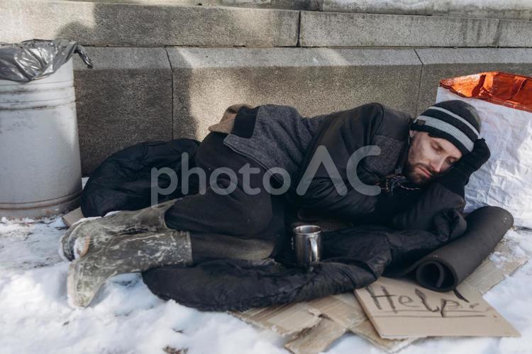 ステンレスのカップを持って寝転ぶ男性 男性,ニット帽,ヒゲの写真素材